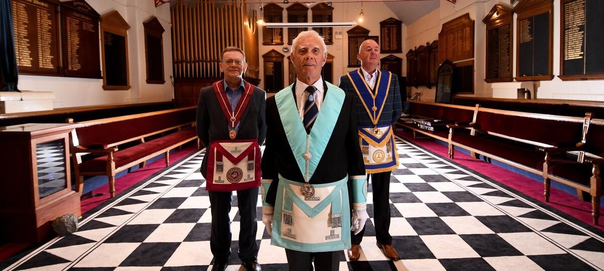 Three Freemasons wearing different ceremonial regalia at Beverley Road Masonic Hall in Hull, representing the Masonic lodges and orders meeting at the Hall. United in Tradition.