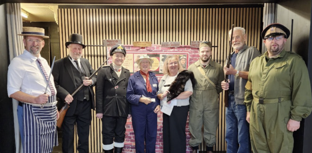Group of guests in formal and traditional costumes gathered together at a community event at Beverley Road Masonic Hall.