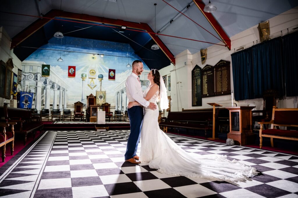 Bride and groom celebrating their wedding inside the historic Large Lodge Room at Beverley Road Masonic Hall in Hull.